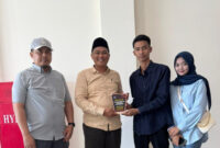 Wagub BEM-F Hukum UNIJA Madura, Ach. Syarif Hidayatullah menyerahkan cendramata kepada Ketua Komisi III DPRD Sumenep, Senin, 21/7/2025 (foto: for NOLESA.COM) 