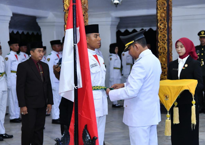 Bupati Sumenep, Dr. H. Achmad Fauzi Wongsojudo secara simbolis memasang kendit  kepada perwakilan Paskibraka sebagai tanda pengukuhan, Jumat, 15/8/2025 (foto: IST) 