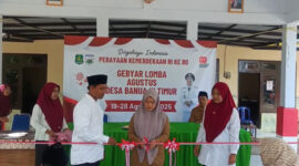 Kepala Desa Banuaju Timur, Dian Megawati, SE menggunting pita pada pembukaan acara HUT ke-80 RI di Balai Desa setempat (foto: for NOLESA.COM) 