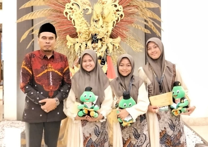 Ketua II LPTQ Sumenep yang juga Kepala Bagian Kesra Kamiludin foto bersama dengan salah satu peraih prestasi dalam MTQ XXXI Jawa Timur (for NOLESA.COM) 