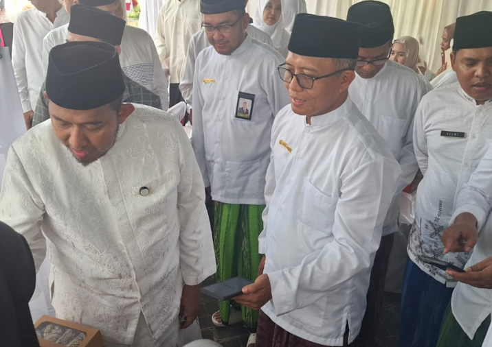 Dirut BPRS Bhakti Sumekar Hairil Fajar bersama Bupati Fauzi mengenakan pakaian layaknya santri (foto: ist) 