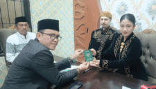 Kepala KUA Kecamatan Kota Sumenep, Marwan menyerahkan buku nikah usai akad (Foto: Istimewa)