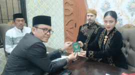Kepala KUA Kecamatan Kota Sumenep, Marwan menyerahkan buku nikah usai akad (Foto: Istimewa)