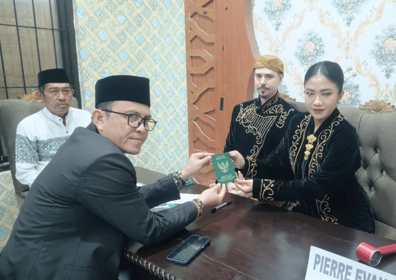 Kepala KUA Kecamatan Kota Sumenep, Marwan menyerahkan buku nikah usai akad (Foto: Istimewa)